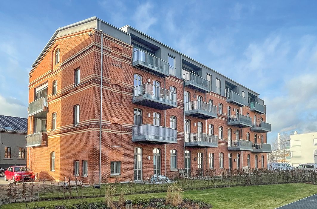 Saniertes Backstein-Wohnhaus mit modernen Balkonen, Bauprojekt Minimax in Neuruppin