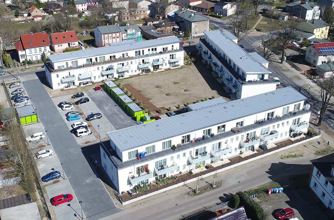 Moderne weiße Wohnanlage in Oranienburg aus der Luft mit Innenhof, Balkonen und Parkplatz